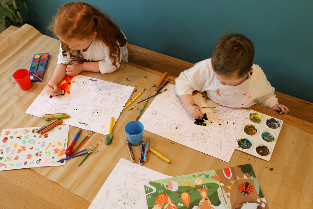 Photo of childern colouring in the Linkilonk Activity Tube. Design in Ireland. Children using paints and colouring pencil. Beautiful red hair. 